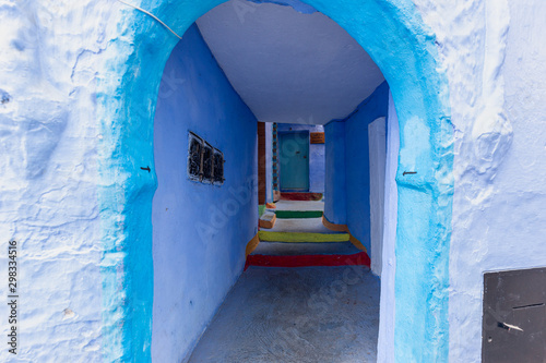 Narrow streets and blue painted houses of Chefchaouen city, Morocco. Most of the streets full of handmade colorful crafts,carpets and souvenir hanged to the walls of the blue houses. © yavuzsariyildiz