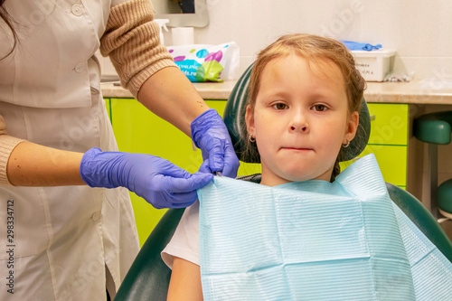 Little Caucasian girl treats teeth at the dentist