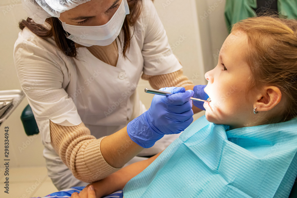 Little Caucasian girl treats teeth at the dentist Little Caucasian girl treats teeth at the dentist