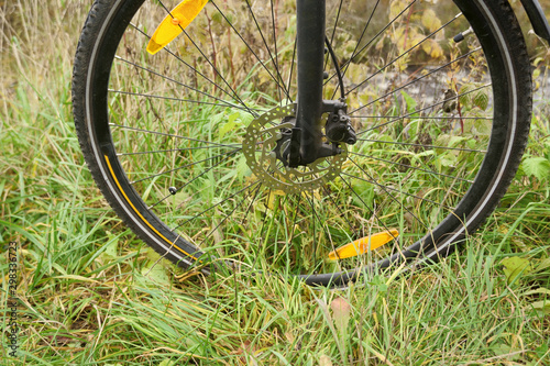 Close-up bicycle wheel on the river bank.
