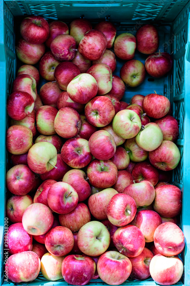 Fresh ripe red apples from orchard, displayed for sale in a plastic box, at a street food market, soft focus Fresh ripe red apples from orchard, displayed for sale in a plastic box, at a street food market, soft focus