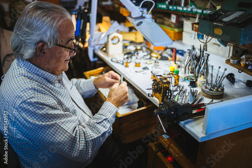 Watchmaker working in watchmaking photo