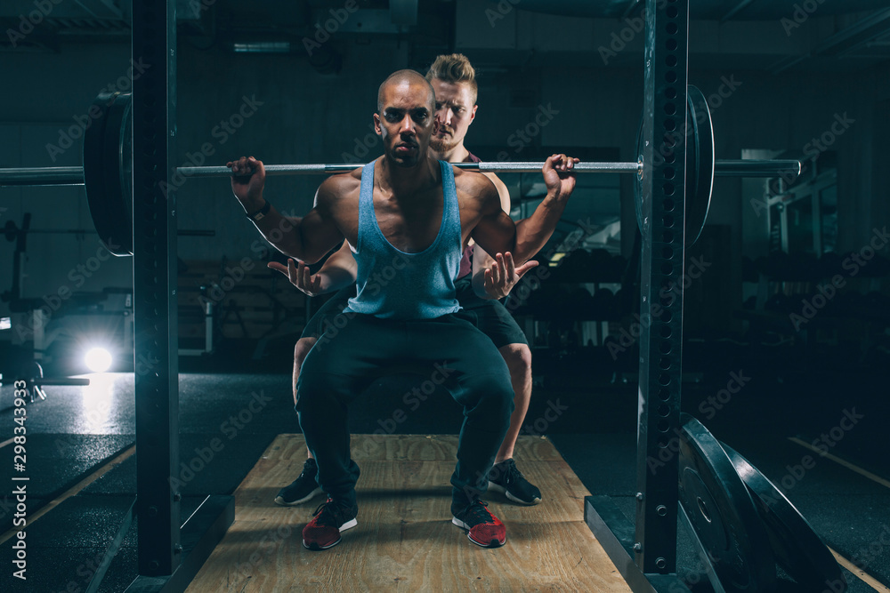 Two friends exercising together in gym Two friends exercising together in gym