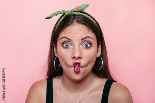 Young woman looking at the camera and making a silly face photo