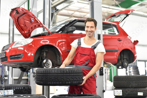 Car mechanic in a workshop, changing tire photo