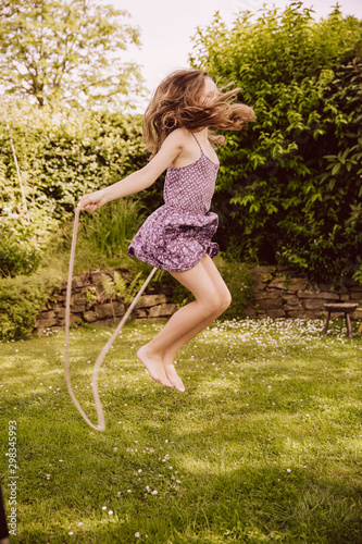 Girl jumping rope in garden