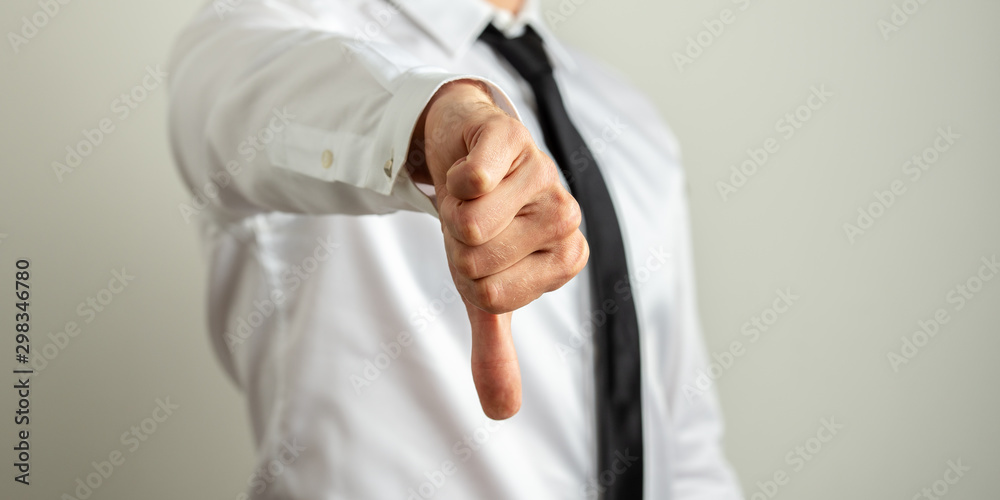 Businessman showing thumb down sign Businessman showing thumb down sign