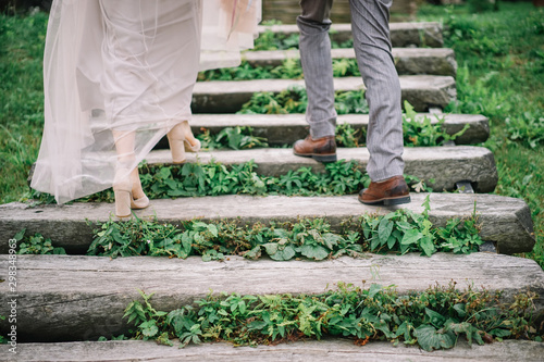 Legs of bride and groom walking up stone steps photo