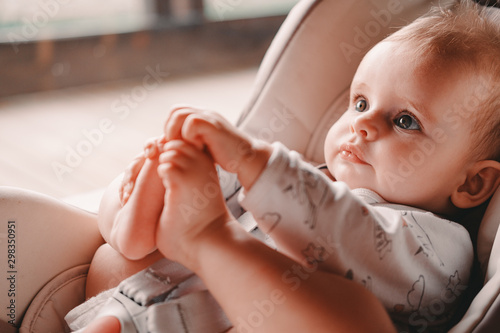 Six month little girl sitting in a car seat on the terrace