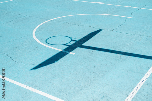 Shadow of a basketball hoop on colorful court