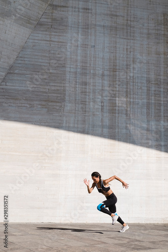 Wallpaper Mural Pulled back view of female athlete running on concrete vertical Torontodigital.ca
