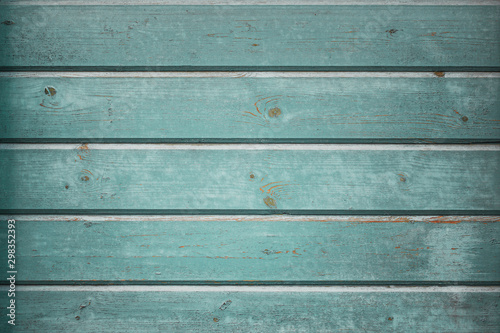 Vintage horizontal wood background texture with peeling paint, pastel wood planks texture background with knots and cracks in cool blue and green tones.