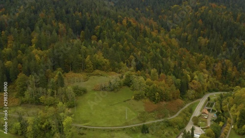 Aerial view of the village  Bad Rippoldsau in Germany on a cloudy day in autumn, fall. Pan to the right along the street out of the village. photo