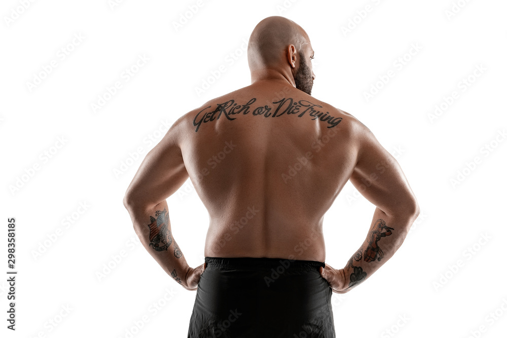 Athletic bald, tattooed man in black shorts is posing isolated on white background. Close-up portrait.
