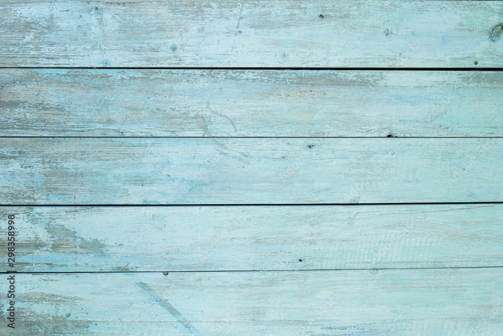 Fototapeta premium old wooden fence light blue paint peeling board texture. Background