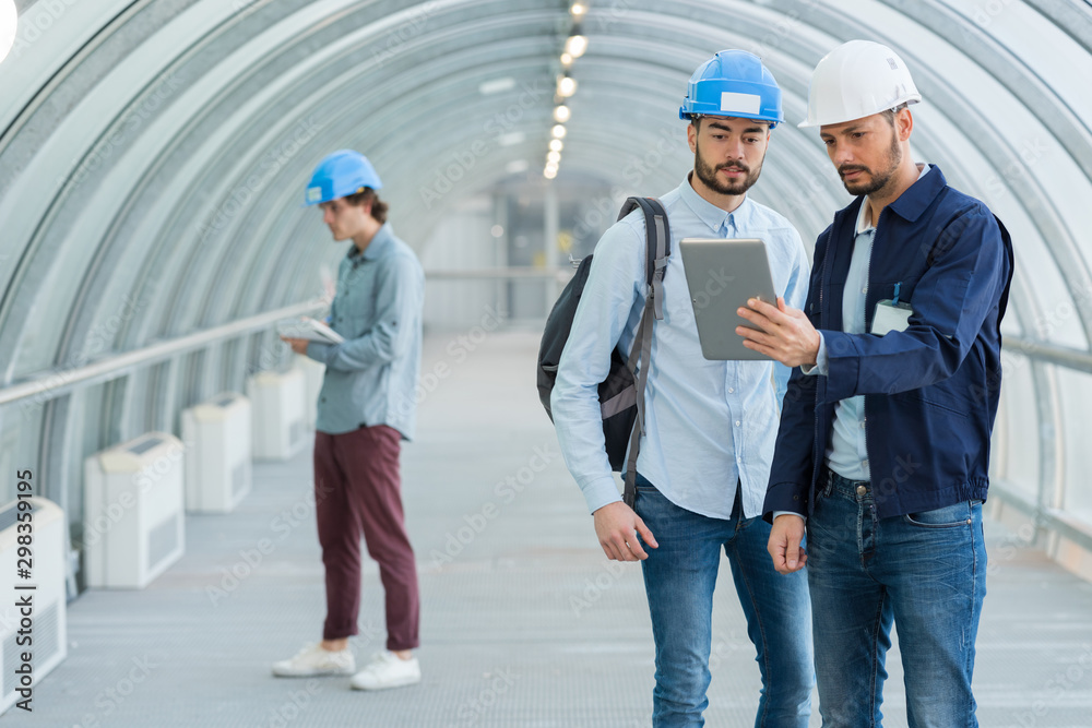 blue-collar workers looking at tablet blue-collar workers looking at tablet