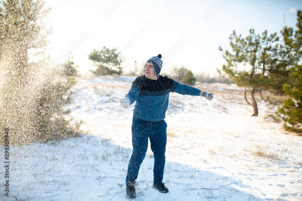 Loving couple play snowballs in winter in the forest. The guy sculpts and throws snowballs at the girl. Laugh and have a good time