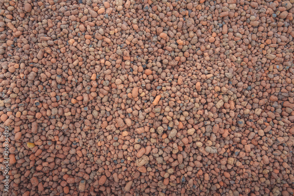 A texture of a red haydite. An expanded clay is a lightweight porous building material.
