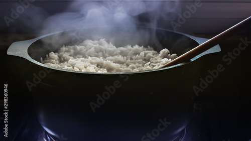 Cocinando arroz en una olla negra con cuchara de madera