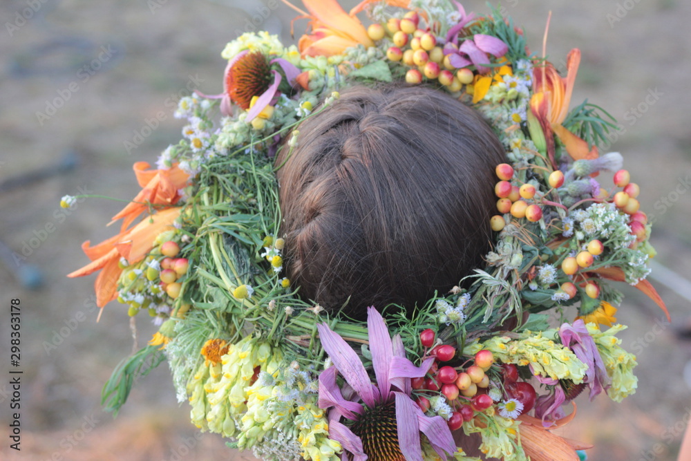 Naklejka premium girl's head in a wreath of wildflowers. young woman in a flower wreath, closeup, back view. Midsummer Celebrations Kupala Night in Ukraine