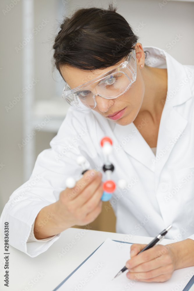 female scientist looking at dna model female scientist looking at dna model