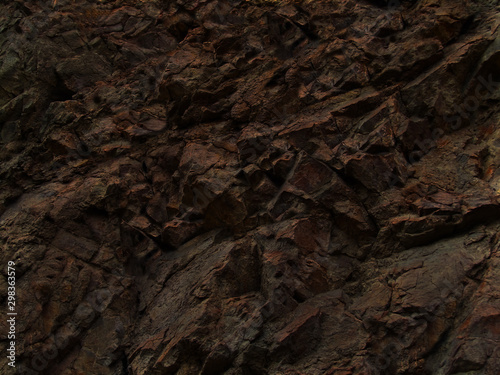 Dark rock background. Black stone texture. Dark brown rough grunge background. Mountain close-up.