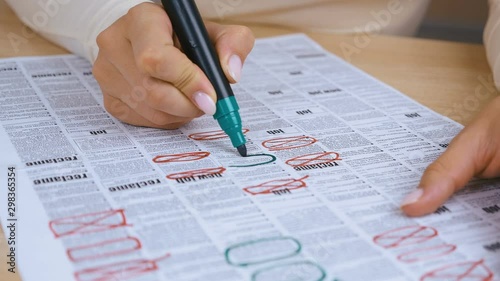 woman Looking for Job in a Newspaper and Marking Advertisement Using green Pencil. 4K