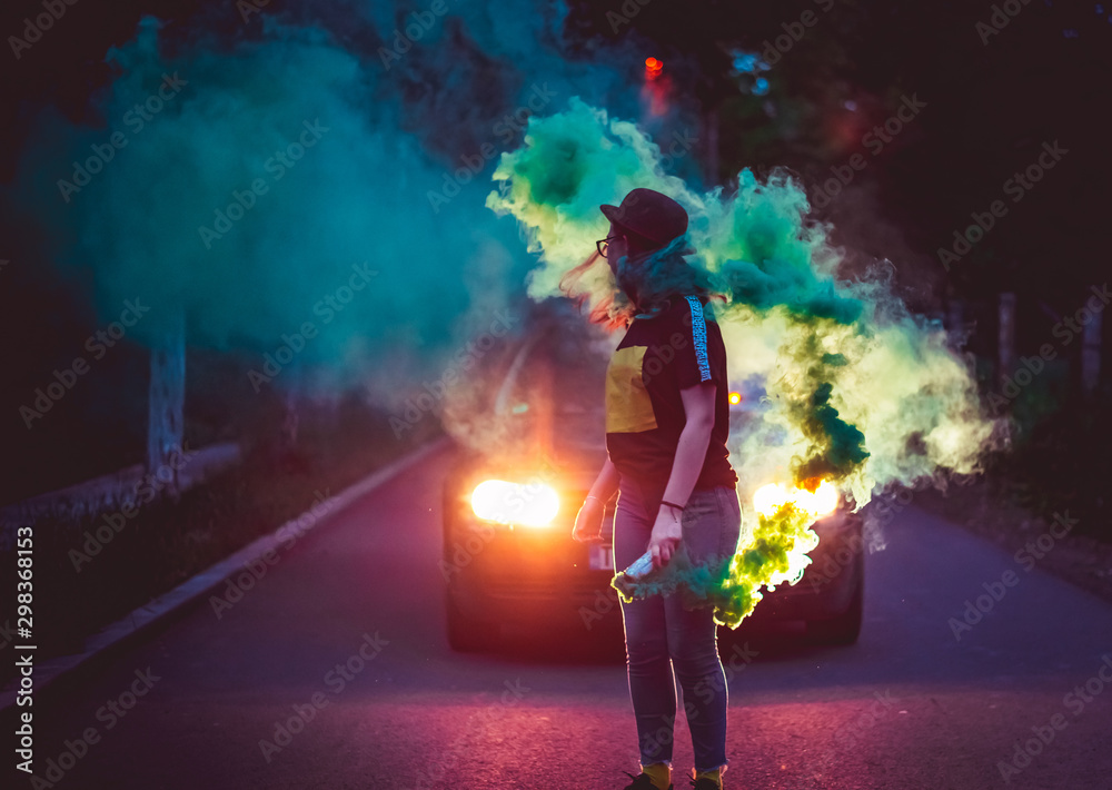 young girl with glasses posing with colored smoke