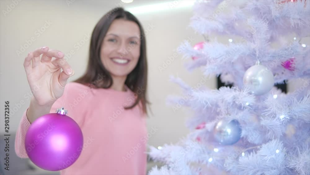 Young woman in a pink sweater showing off what nice toys she has bought for this christmas. Young woman in a pink sweater showing off what nice toys she has bought for this christmas.
