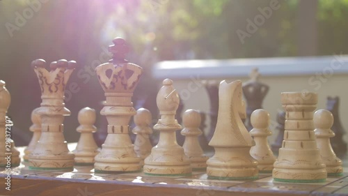 Wooden chess game on a table in a camera slide from right to left.