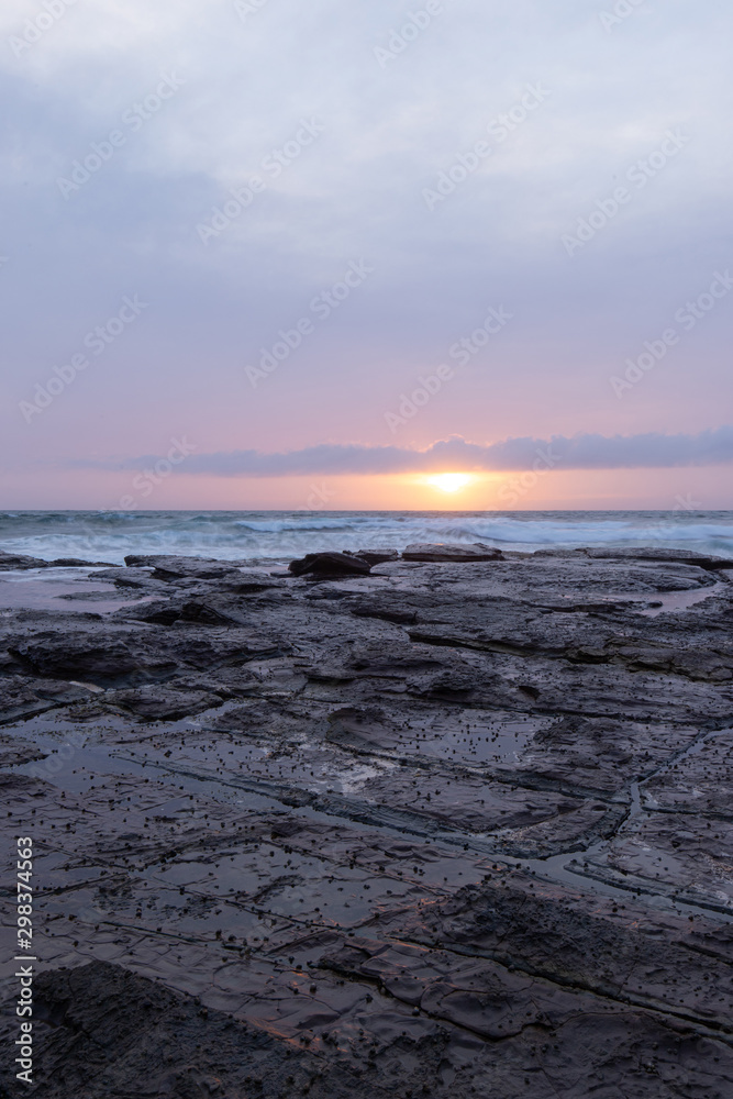 Cloudy sunrise view in the rocky coastline.