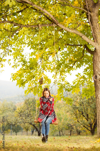 Beautiful young woman on a swing outdoors © bokan