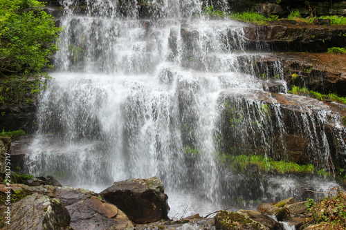 Beautiful close up of amazing waterfall Tupavica on Old mountain, near Dojkinci, with vivid green moss, splashing water and red rocks