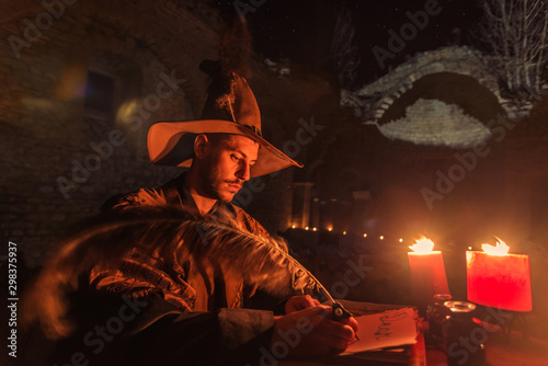 Nostradamus writing his prophesies, fantasy concept. illuminated by candles, long exposure, motion blur, high ISO photo