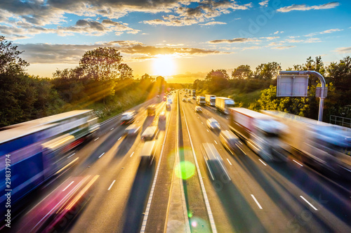 Fototapeta heavy traffic moving at speed on UK motorway in England at sunset