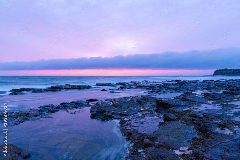 Rocky coastline under the overcast sunrise light.