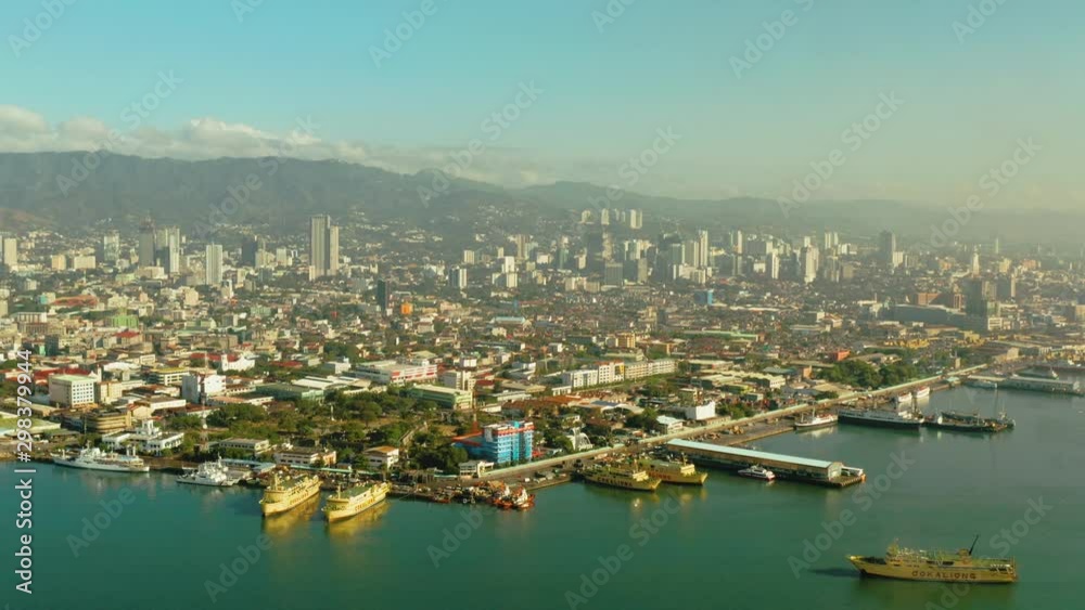 Cebu city overview: seaport with ships and ferries. Capital city of the province of Cebu and is the second city of the Philippines after Metro Manila during sunrise. Cebu city overview: seaport with ships and ferries. Capital city of the province of Cebu and is the second city of the Philippines after Metro Manila during sunrise.