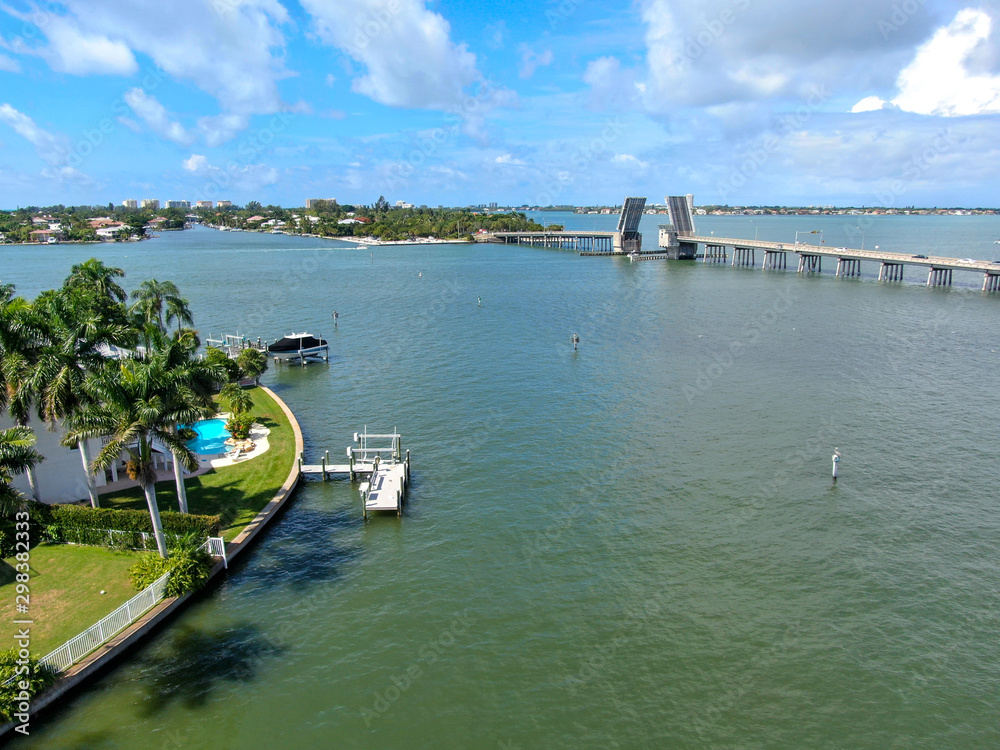 Aerial view of open street bridge crossing ocean with small boat and linking Island Bay and Sarasota, Florida, USA Aerial view of open street bridge crossing ocean with small boat and linking Island Bay and Sarasota, Florida, USA