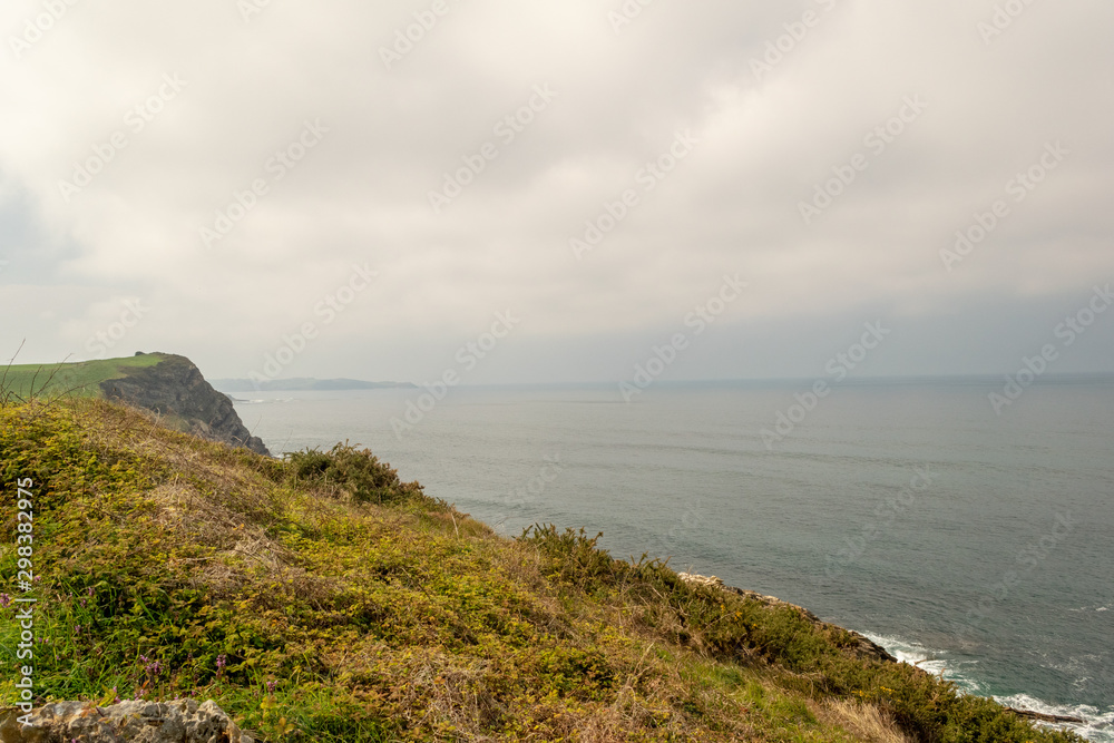 Cliffs in the sea with a cloudy sky. Cantabrian coast in the Atlantic Ocean. Cliffs in the sea with a cloudy sky. Cantabrian coast in the Atlantic Ocean.