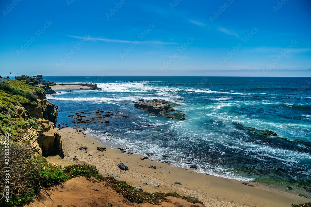 The bright blue waters of the Pacific Ocean along the shoreline of La Jolla, San Diego, California, USA on a bright and sunny beautiful day.