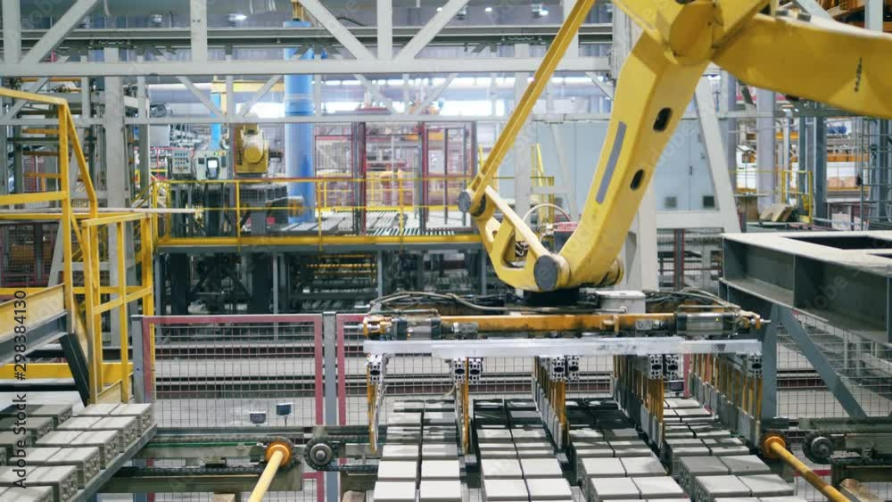 Automated, robotic machine moves bricks from a working conveyor. Automated, robotic machine moves bricks from a working conveyor.