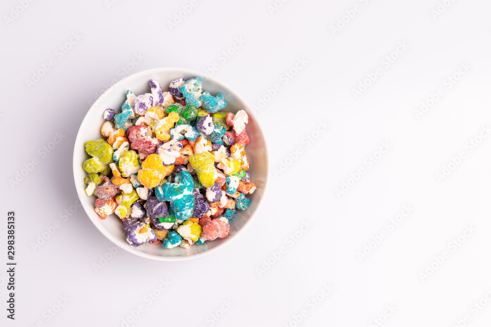 Colored Popcorn candy isolated on white background, soft light, studio shot, copy space. Junk food, fruit flavored popcorn. Colorful, multicolor, candy coated popcorn