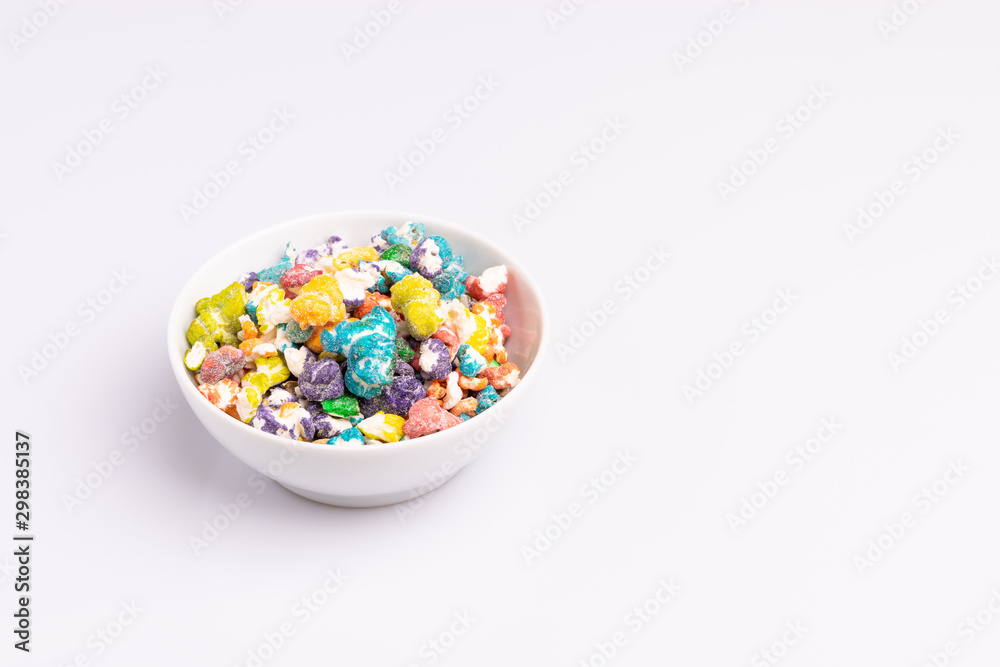 Colored Popcorn candy isolated on white background, soft light, studio shot, copy space. Junk food, fruit flavored popcorn. Colorful, multicolor, candy coated popcorn