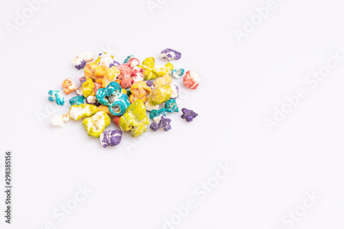 Colored Popcorn candy isolated on white background, soft light, studio shot, copy space. Junk food, fruit flavored popcorn. Colorful, multicolor, candy coated popcorn