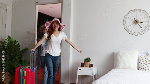 Two girl friends asian with suitcases Walked into the guesthouse or hostel in order to stay in a room and Lay down on the bed at home. trip holiday travel vacation.