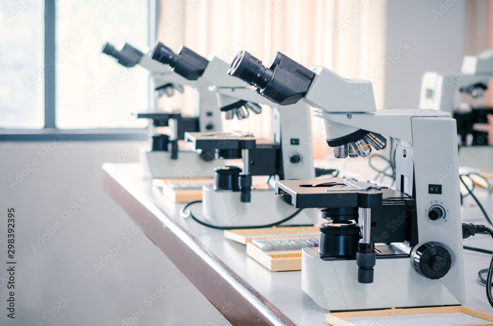 Row of Microscope with micro plate on white table in laboratory setting for research and learning Row of Microscope with micro plate on white table in laboratory setting for research and learning