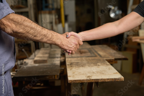 Handshake of man and woman in carpentry.