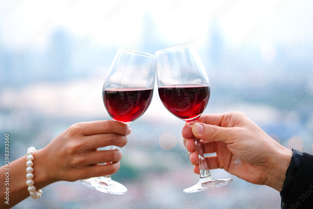 Hand of group friends celebrate successfully with red wine in the party. Young toasting in party and drinking after work hard for relax and be enjoy. Celebration Concept , Cheers!