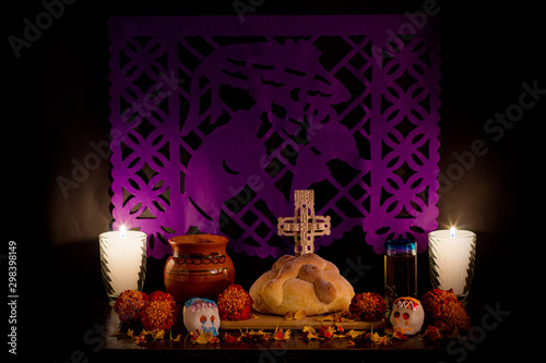 Ofrenda de la celebración de día de muertos con pan, velas y papel picado. photo