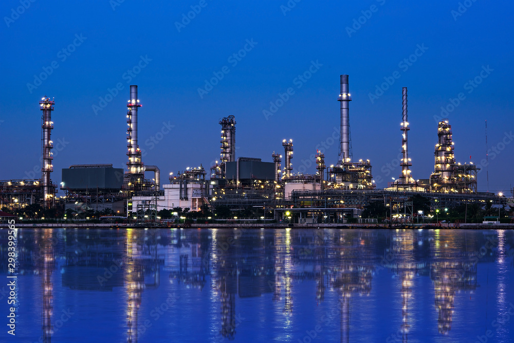 Oil and gas refinery plant area near the river at twilight, sunset time